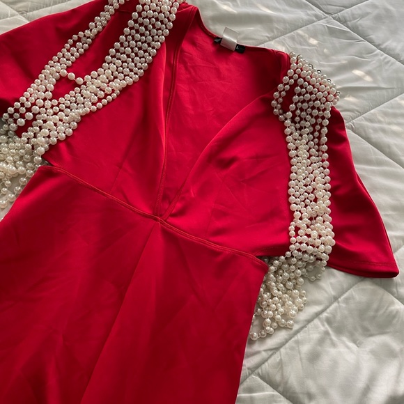 Vibrant Red Jumpersuit with structured pearl draped along shoulder pads. - Picture 4 of 5
